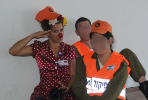 Medical clown Hagar Hofesh with soldiers at a hospital shelter near Gaza.