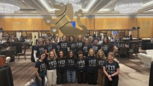 Group of women in matching tshirts standing in front of a Lion of Judah statue,