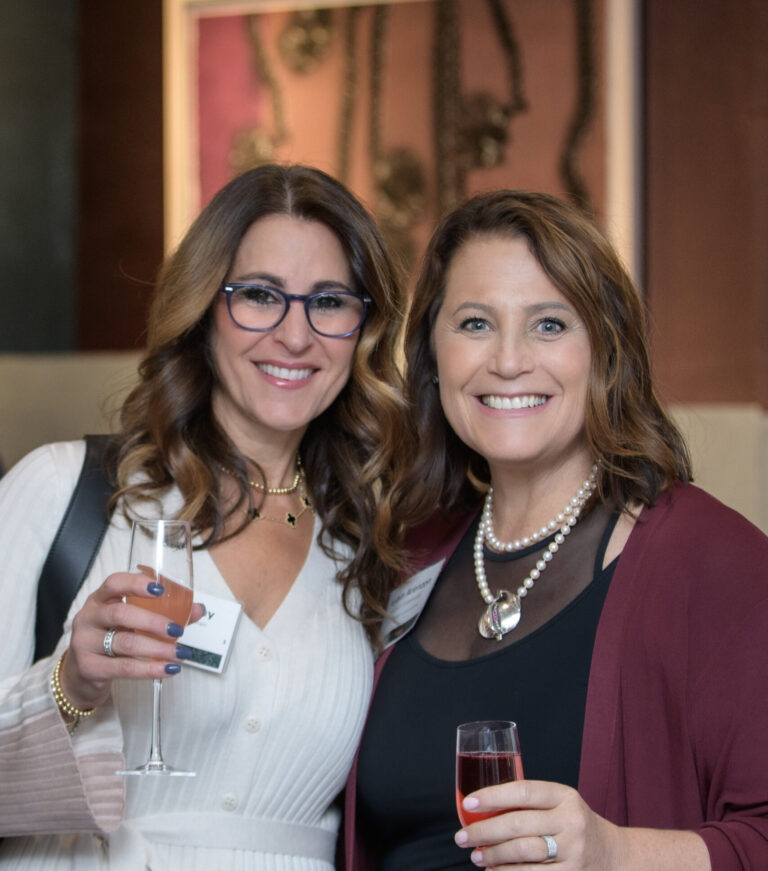 Two women smiling with cocktails