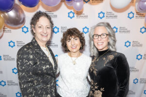 three women smiling at an event