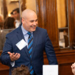 man in suit smiling and talking
