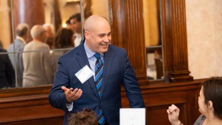 man in suit smiling and talking