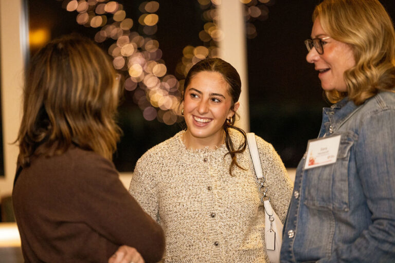 A young professional woman having a happy conversation with two other women