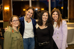 Group of four women at an event smiling