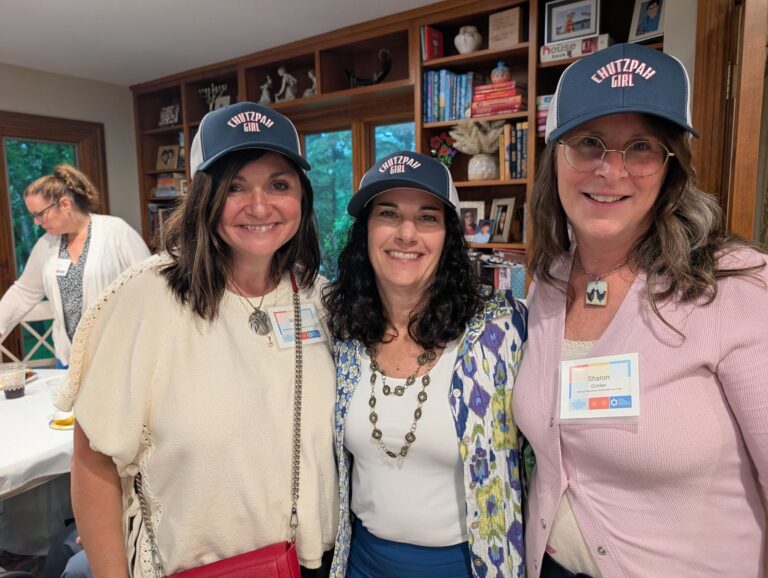 Three women in baseball caps that say Chutzpah Girl