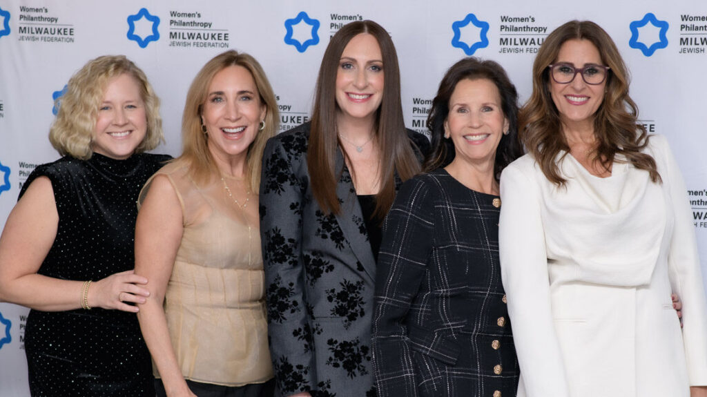 Group of five women at an event smiling