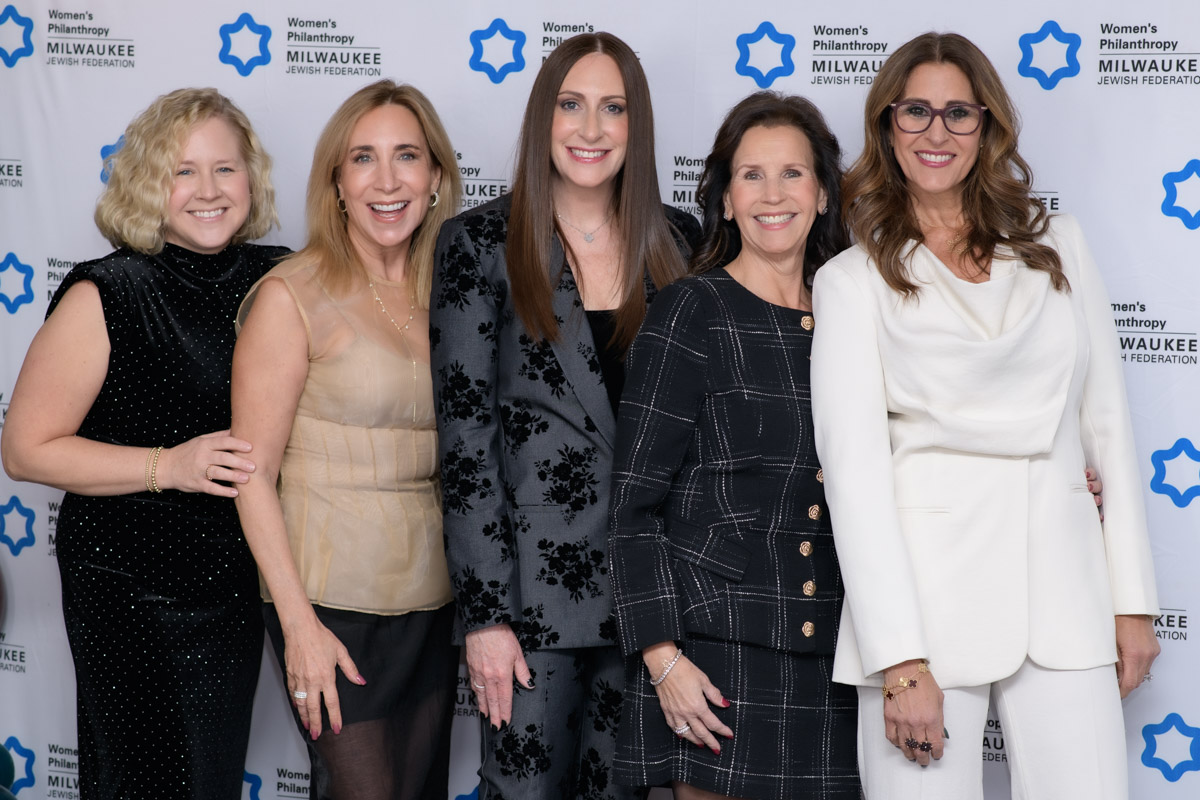 group of five women at an event smiling