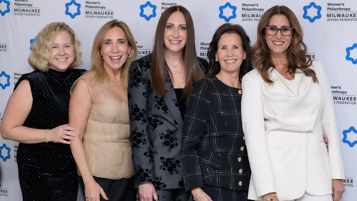 group of five women at an event smiling