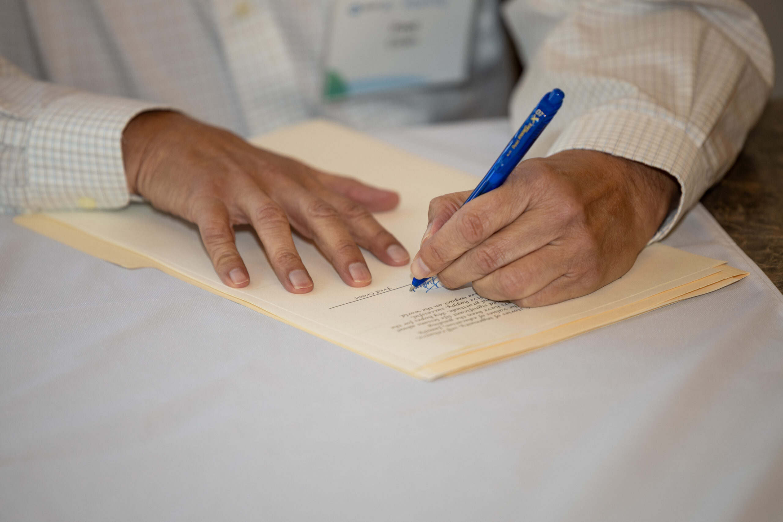 a person signing a piece of paper