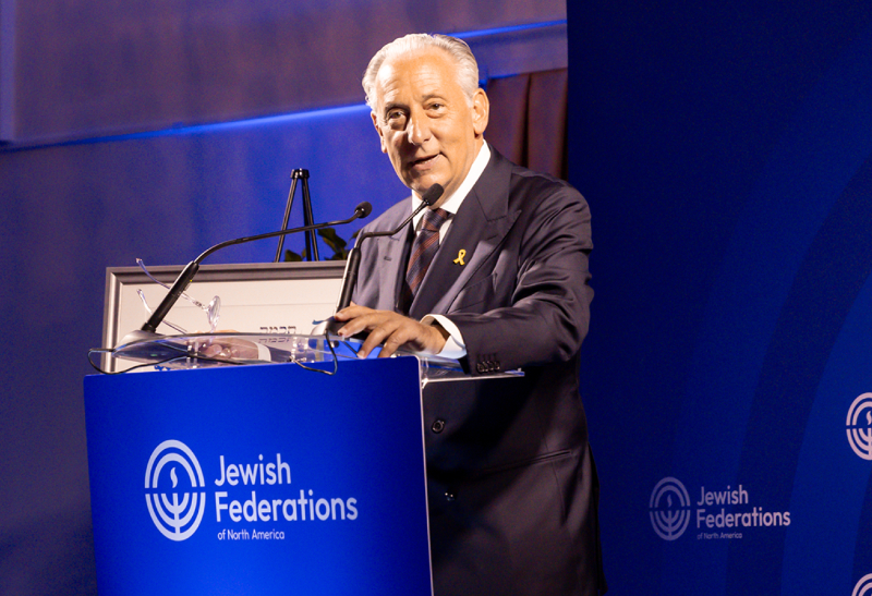 Man in a suit speaking at a podium