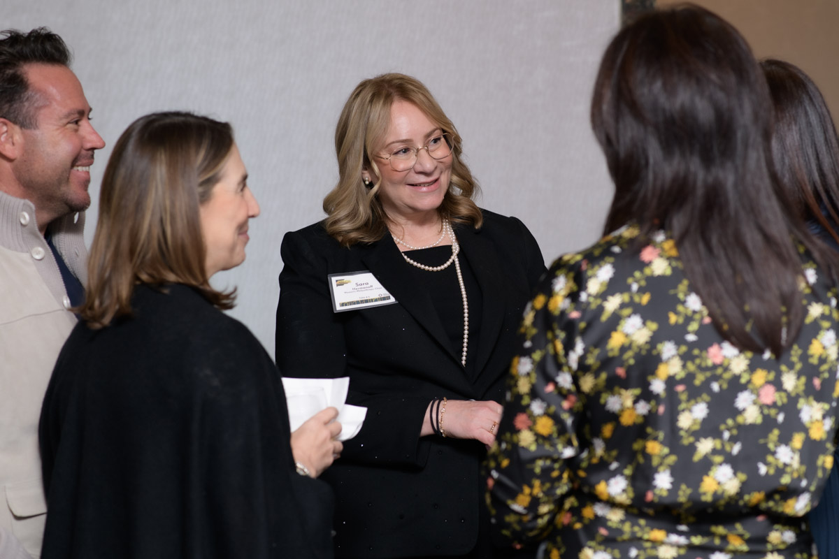 Woman smiling standing with a small group of people in professional attire