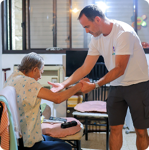 Adult helping elder get up from chair.