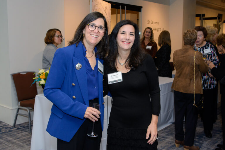 Two women smiling at a professional event