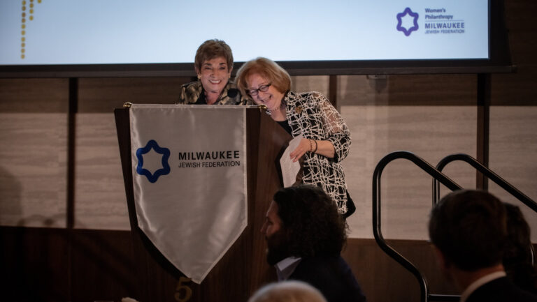 Two women laughing and smiling at a podium