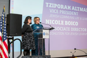 two women speaking at a podium