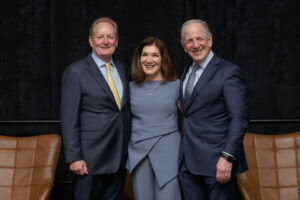 three professional business leaders smiling