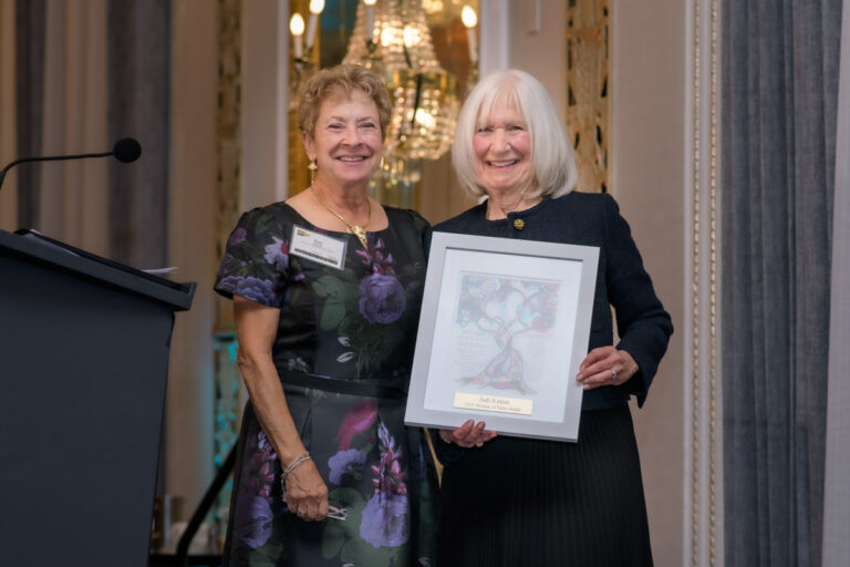 two women, one holding an award