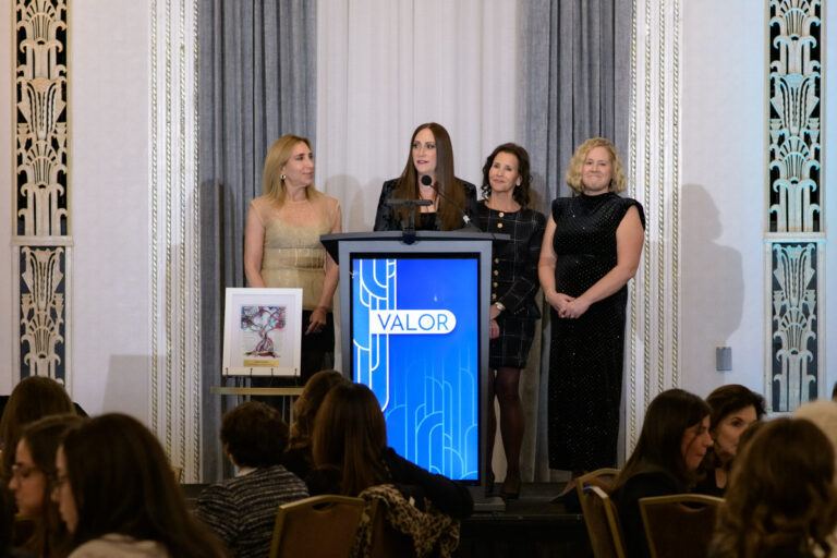 four women standing a podium