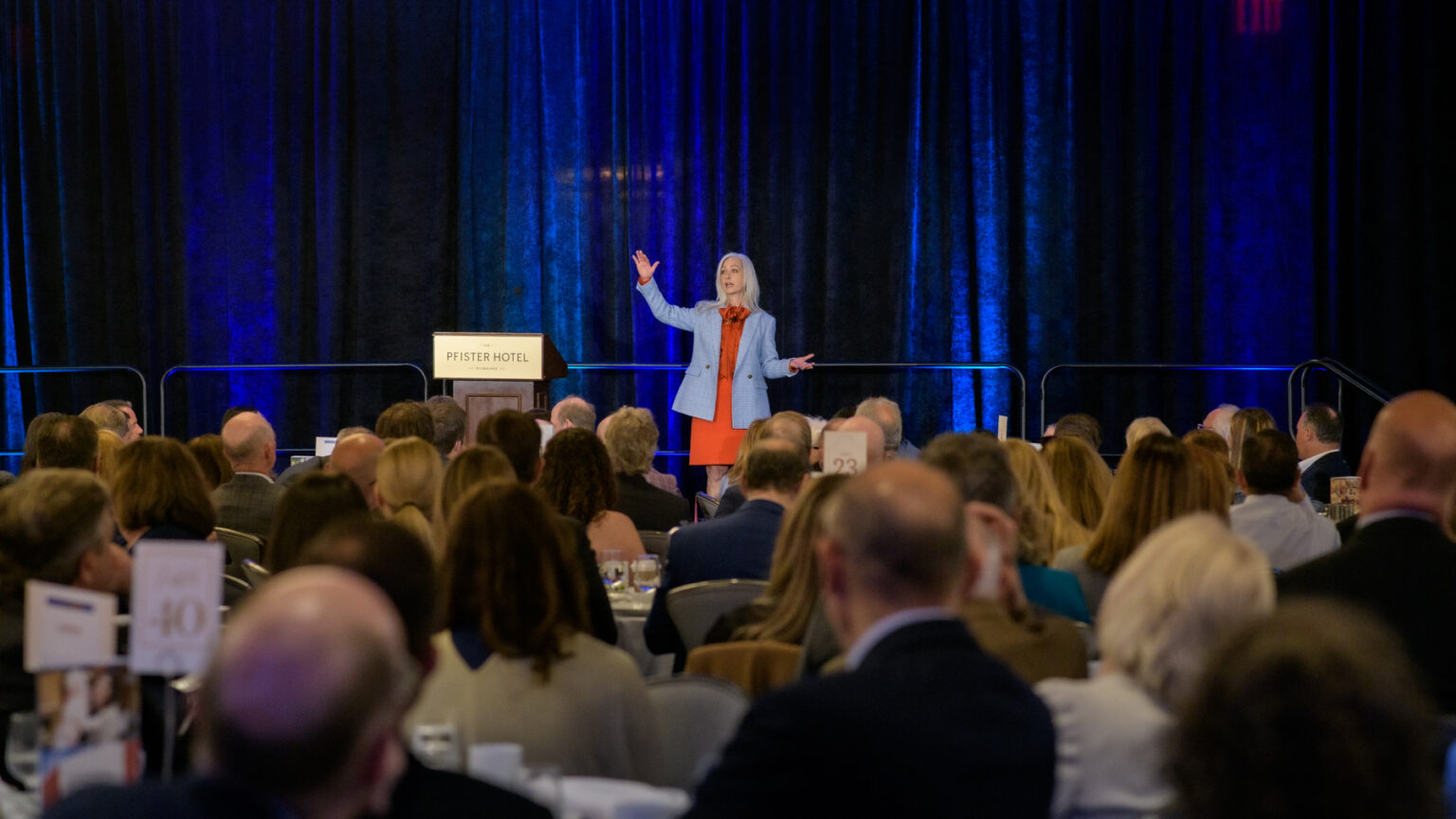 A woman giving a presentation to a large room of people