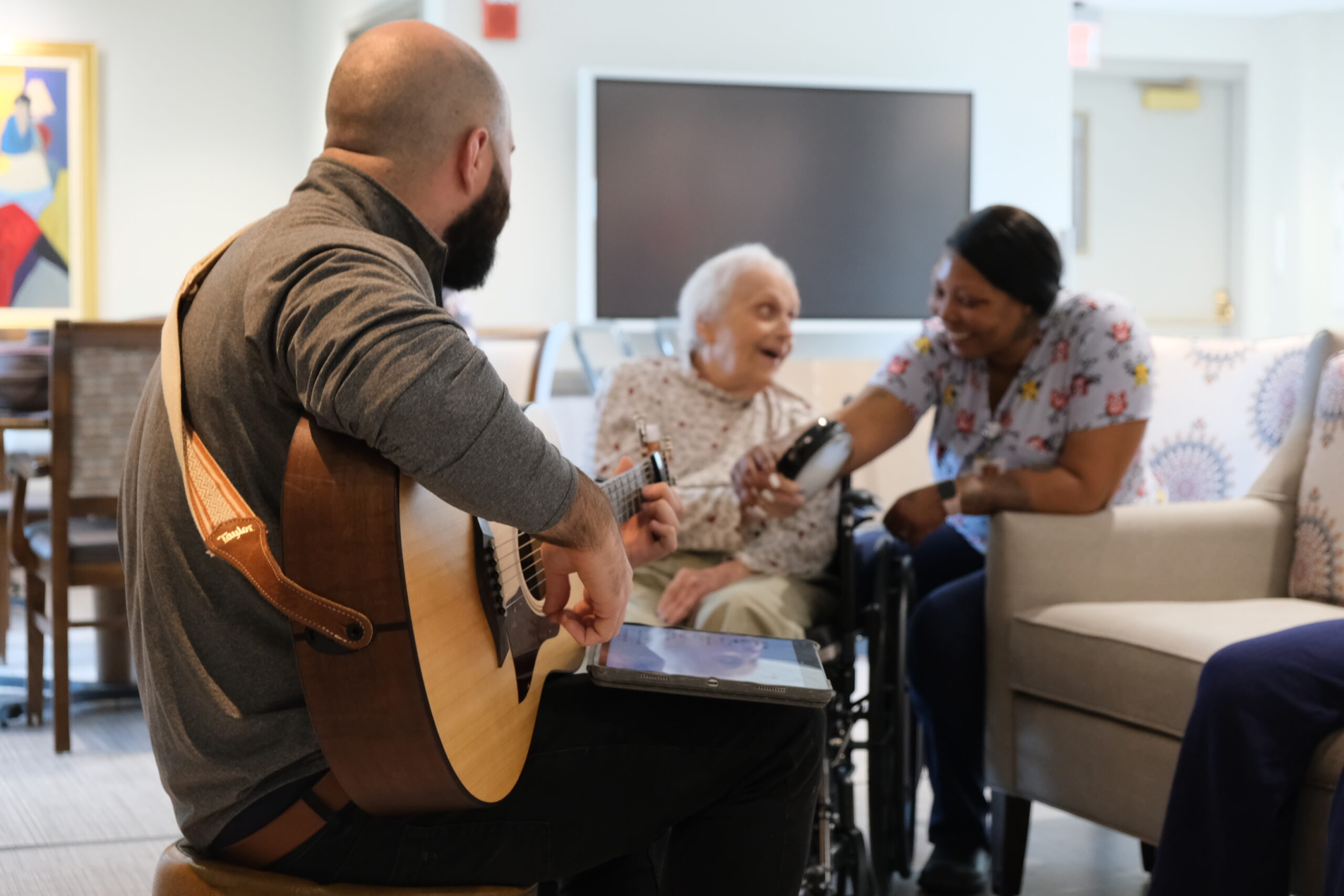Man playing guitar for two women