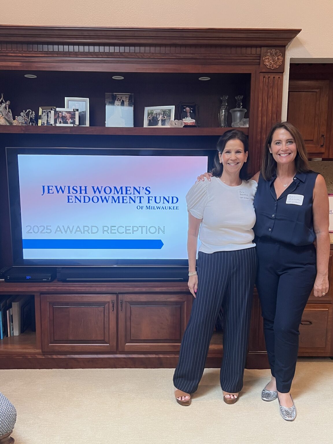 two women standing in front of a sign that reads 2025 award reception