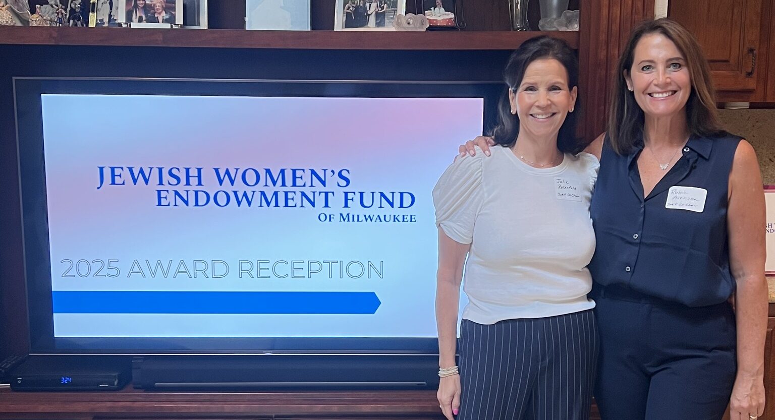 two women standing in front of a sign that reads 2025 award reception