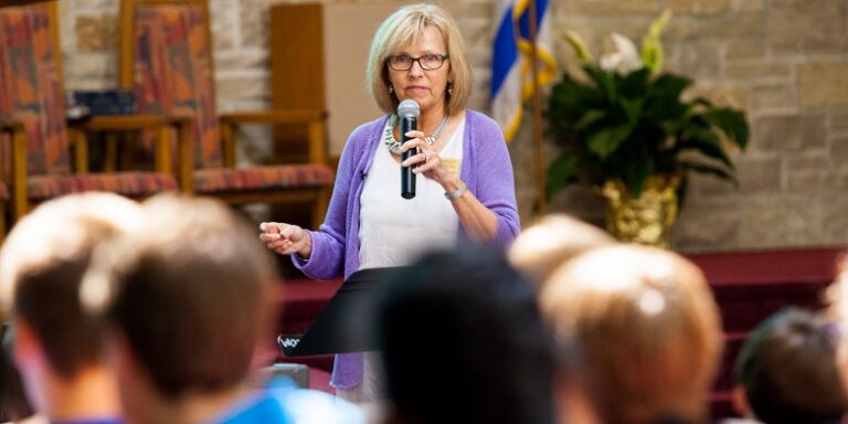 A woman speaking in front of crowd