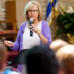 A woman speaking in front of crowd