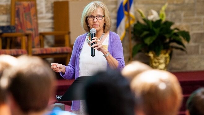 A woman speaking in front of crowd