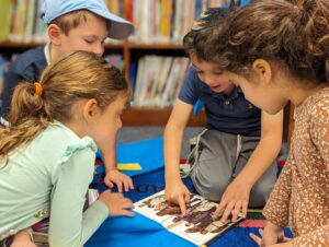 four kids looking at a star wars book
