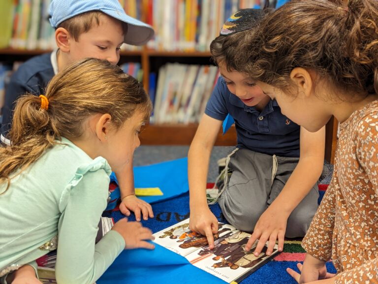 four kids looking at a star wars book