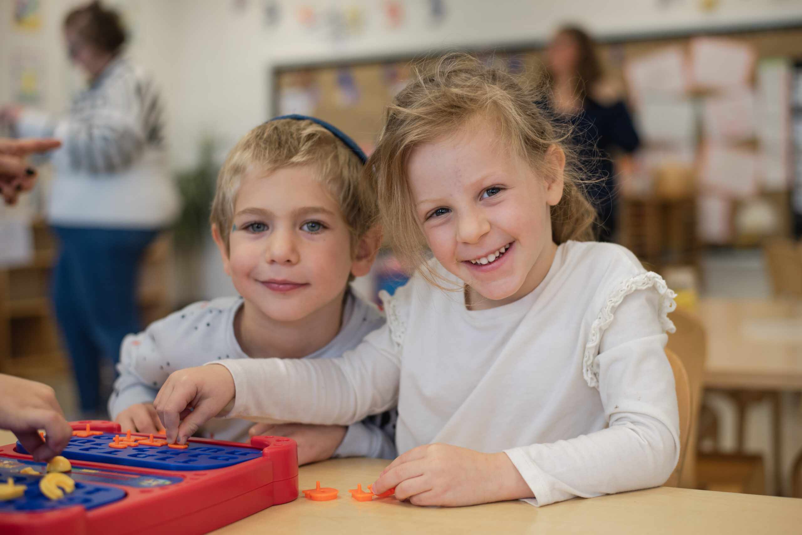 Two kids smiling at a table