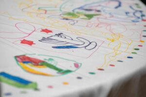Kids drawings on table cloth.