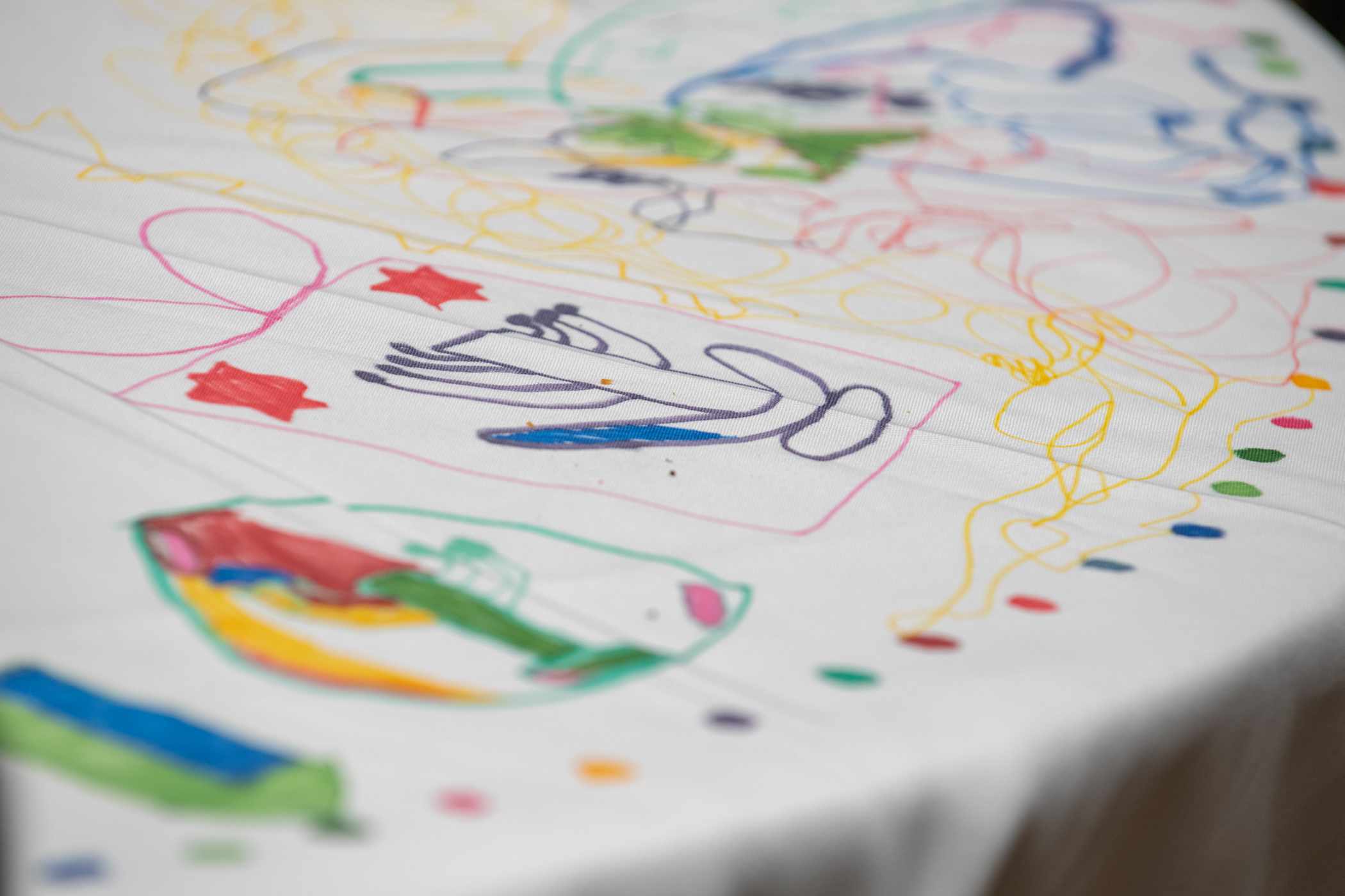 Kids drawings on table cloth.