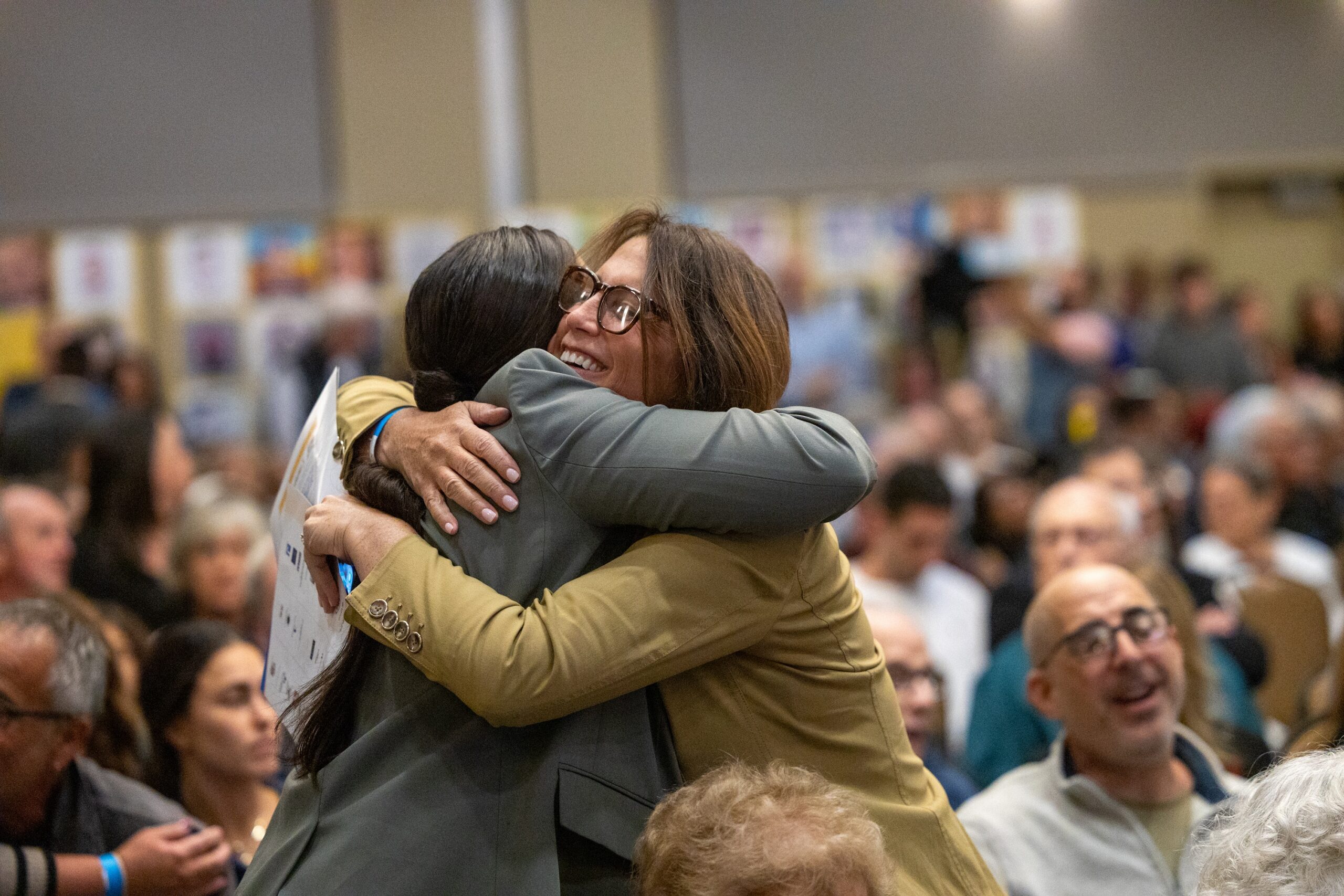 Milwaukee community members embracing joyfully at a Milwaukee Jewish Federation event.
