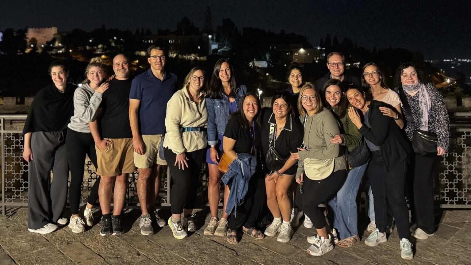 group of young professionals at night in Israel smiling for a group photo
