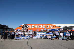 large group picture in front of plan