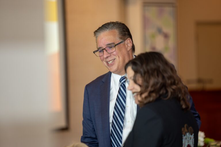 A man in a suit smiling