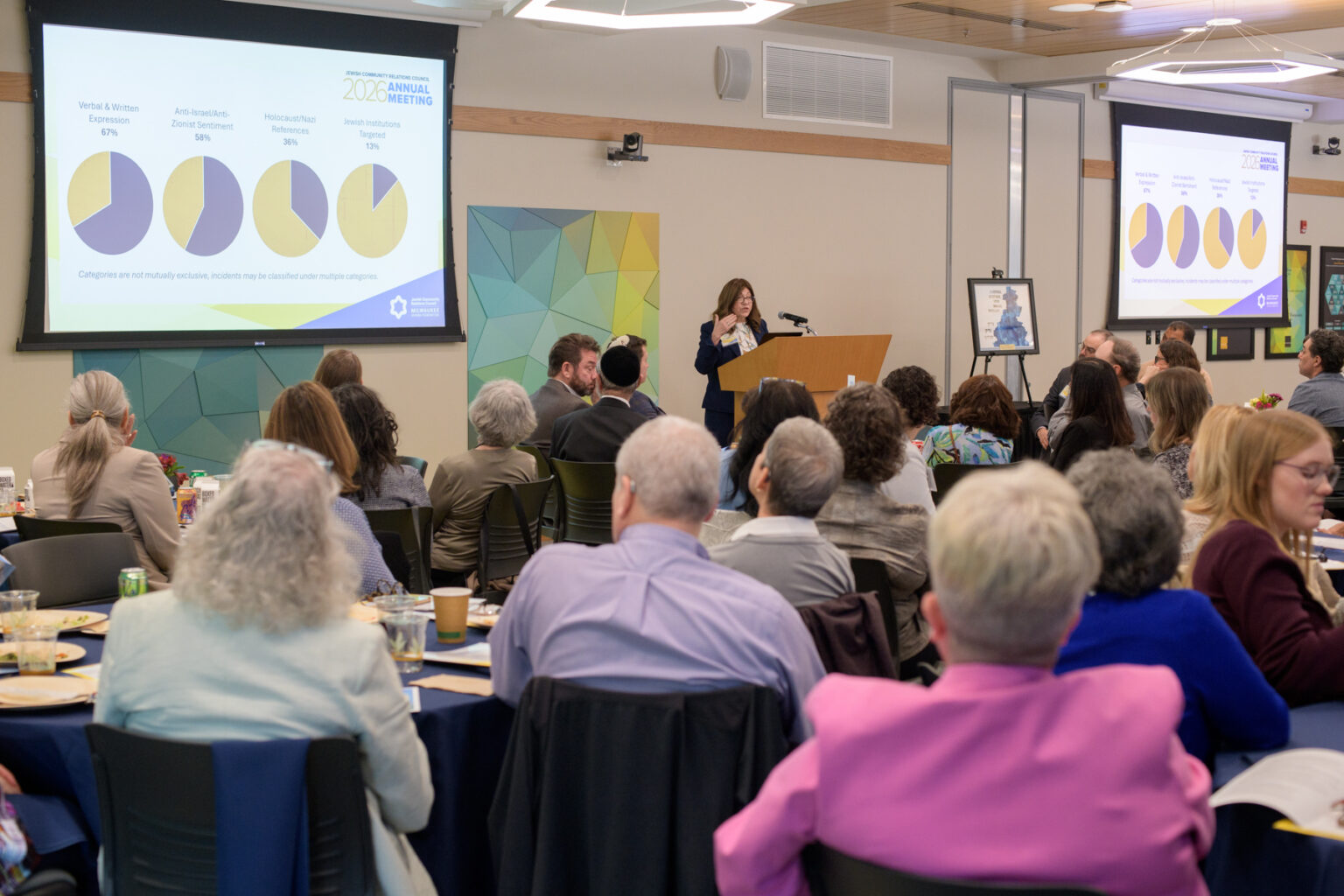 a woman presenting to a large room of people
