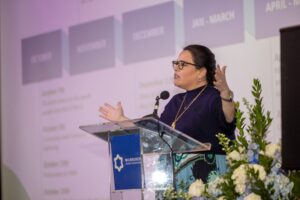 Person on speaking on stage at a meeting.