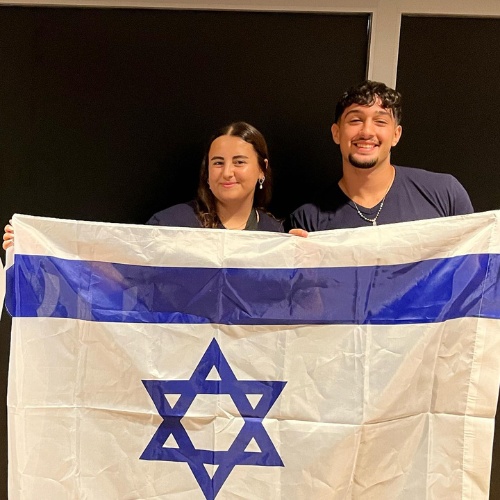 Boy and girl smiling holding a flag