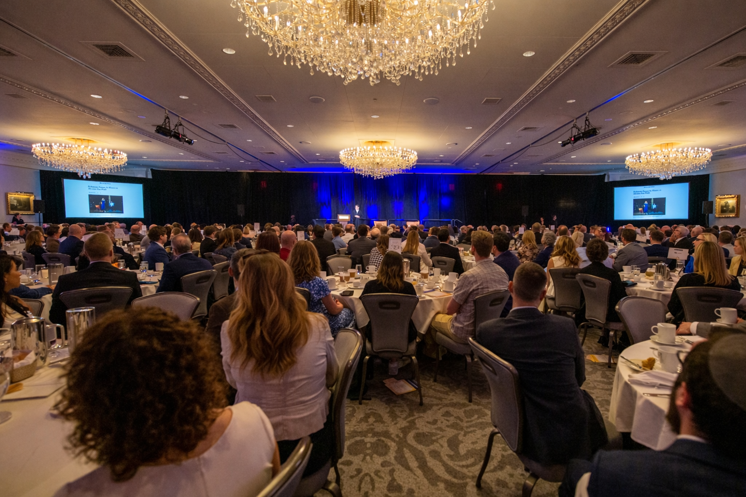 a ballroom full of event attendees watching the stage
