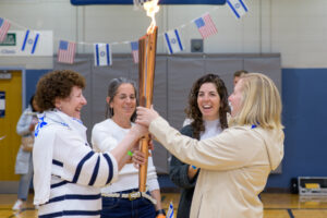 a group of women holding a torch